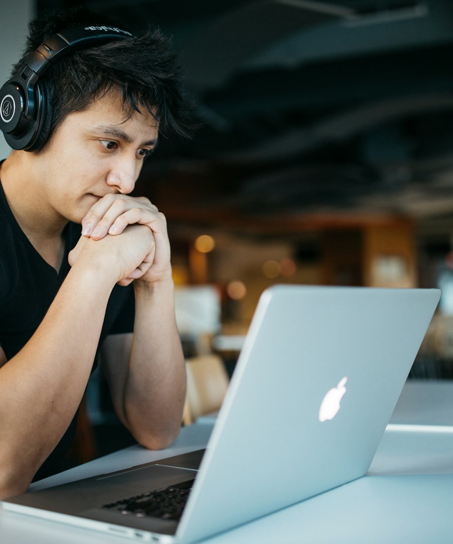 Student with headphones studying on a laptop